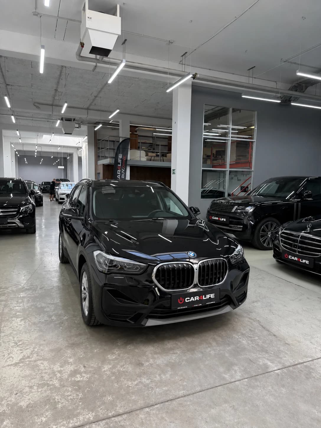 Автомобильный зал Car4Life с BMW на переднем плане